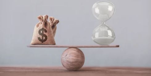 Houten bal met daarop een plank die in evenwicht gehouden wordt door geld aan een zijde en zandloper aan andere zijde. Een weegschaal die waardebepaling bij huizenruil voorstelt.